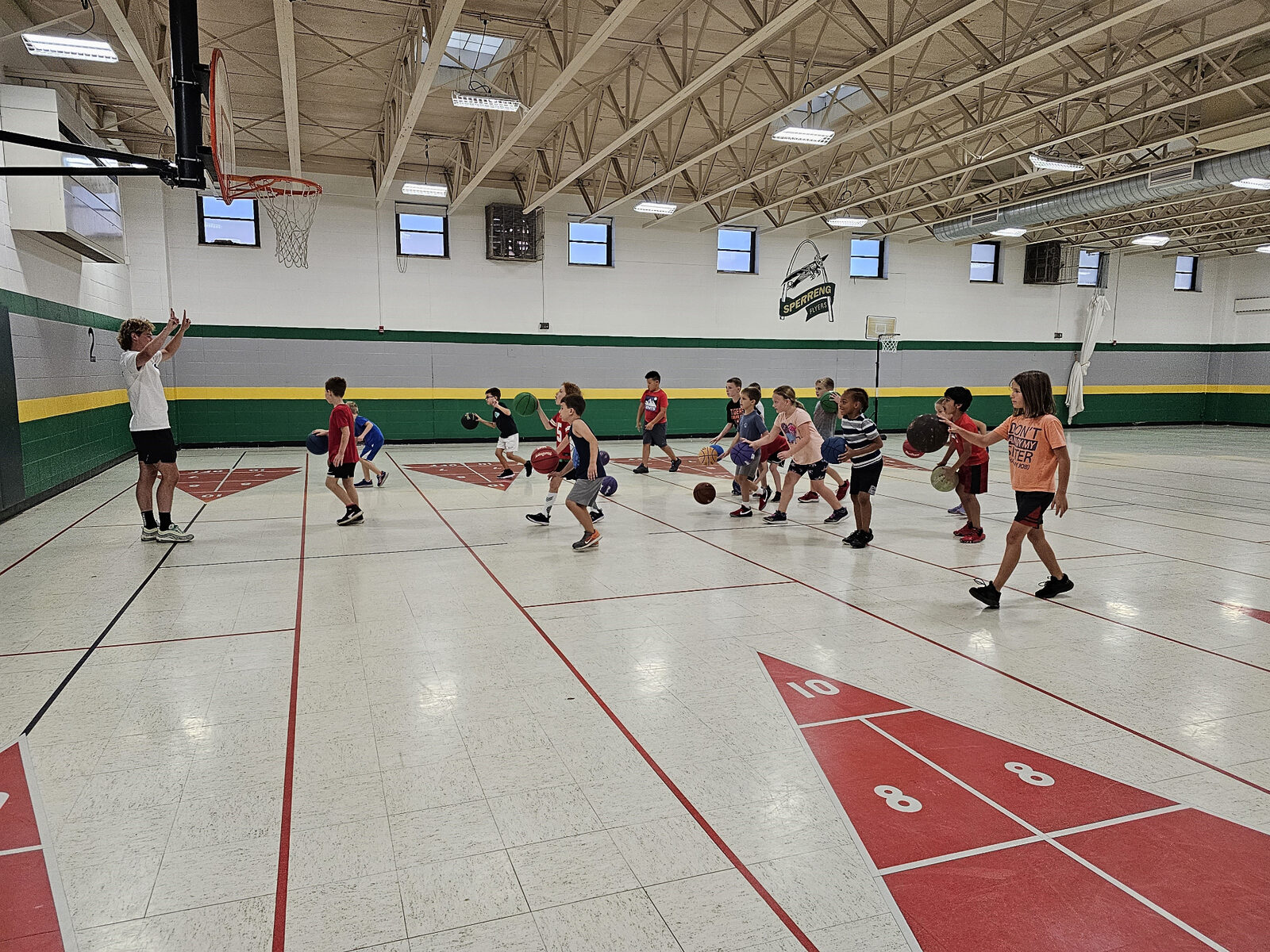 A Recreation Academy coach running a basketball drill in the gym