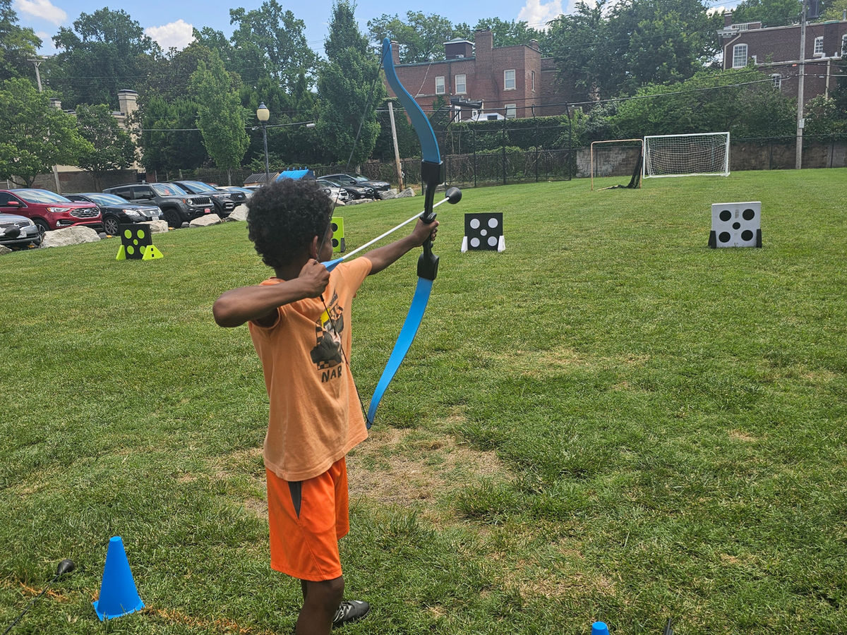 Two Recreation Academy campers smiling with foam-tipped archery bows